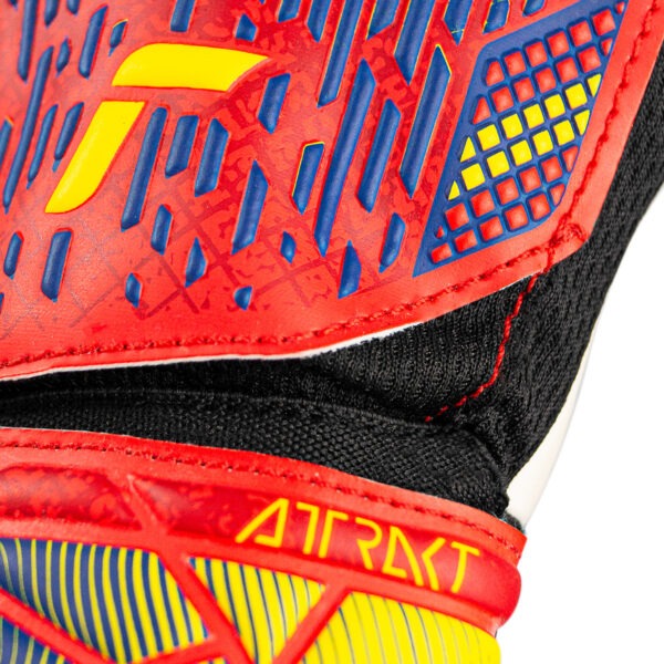 Close-up of the Reusch Attrakt Solid Junior Spain goalkeeper glove showing the embossed backhand design, Attrakt branding, and textured wrist area.