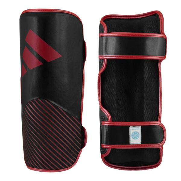 Front and inner view of the Adidas WAKO shin guards in black and red with hook-and-loop straps, cushioned lining, and WAKO approved label.