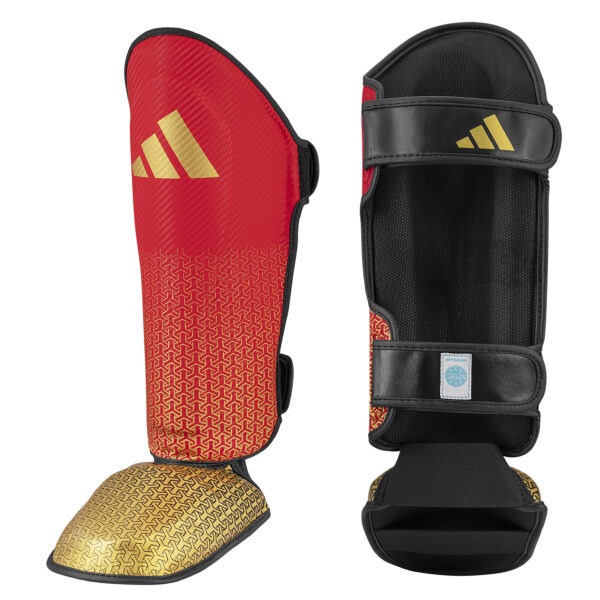 Front and inner view of the Adidas WAKO shin guards with removable in-step protection in red and gold featuring hook-and-loop straps, cushioned lining, and WAKO approved label.